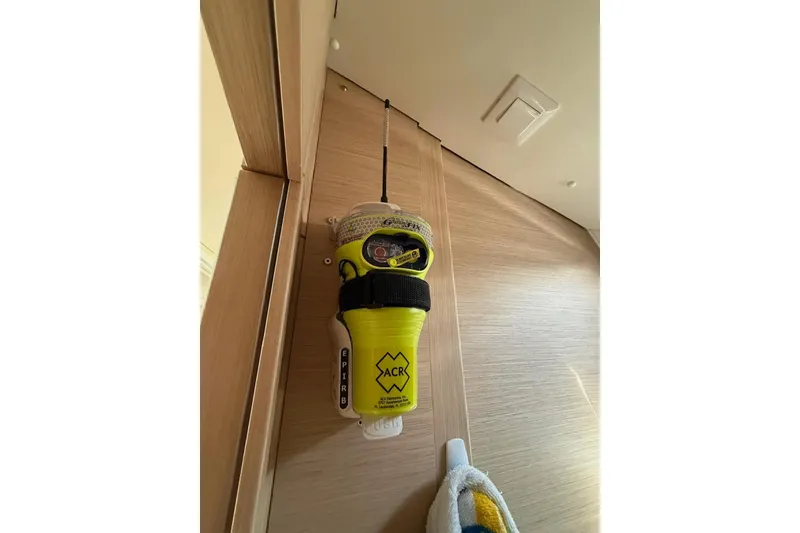 Slide: The Image of Yellow EPIRB device mounted on a wooden wall inside a 2018 Jeanneau 51 yacht. - 32