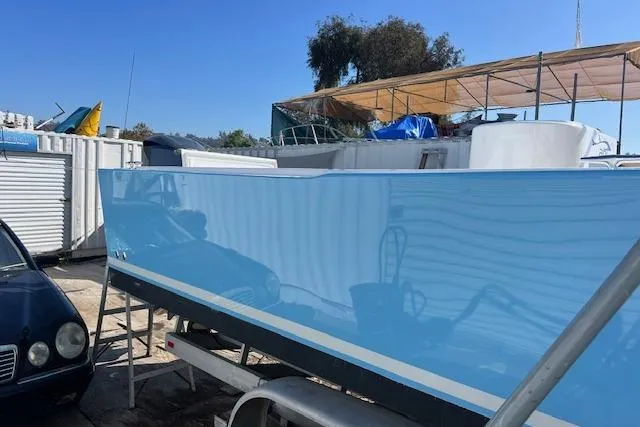 Slide: The Image of 1971 Mariners BAJA 30 boat with a sleek blue hull, parked outdoors under a canopy. - 6