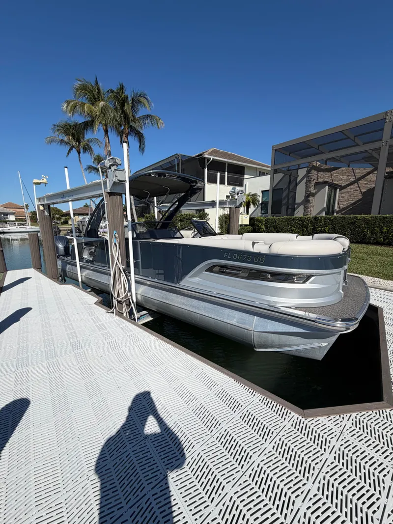 Slide: The Image of 2021 Avalon Excalibur Twin Elite Pontoon at dock, sunny day. - 2