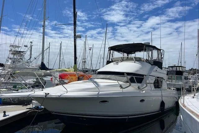 The Image of 1997 Silverton 351 Sedan Cruiser docked at marina under blue sky. - 1