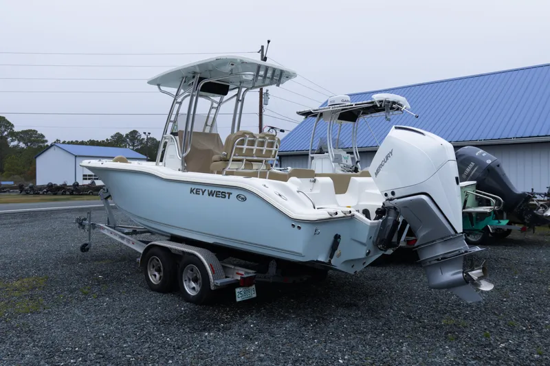 Slide: The Image of 2020 Key West 239 FS boat on trailer with Mercury outboard engine, parked outdoors. - 2