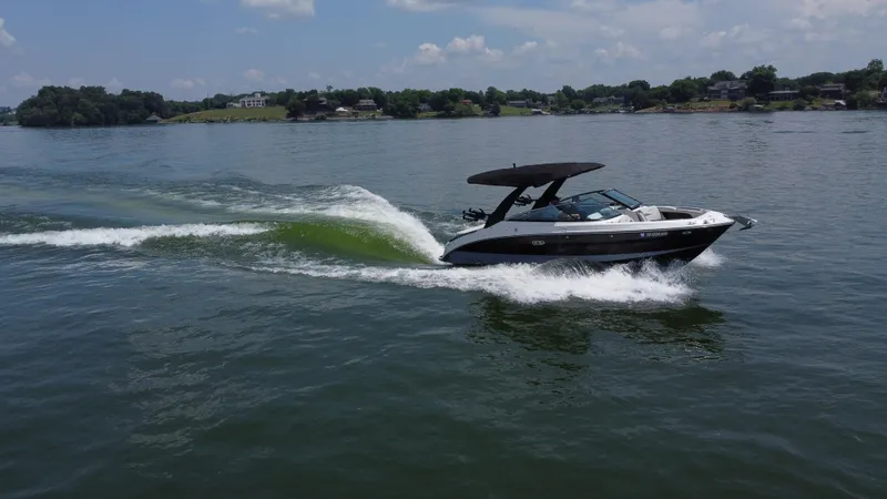 Slide: The Image of 2023 Sea Ray SLX 260 Surf boat cruising on a lake under a clear sky. - 15