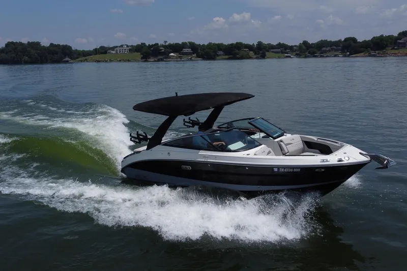 Slide: The Image of 2023 Sea Ray SLX 260 Surf boat cruising on a lake under a clear sky. - 16