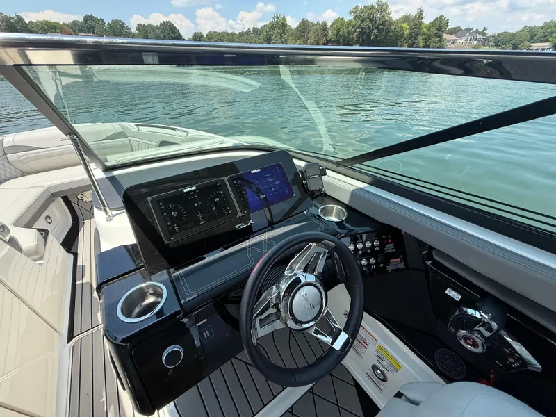 Slide: The Image of 2023 Sea Ray SLX 260 Surf boat dashboard with modern controls and scenic water view. - 19