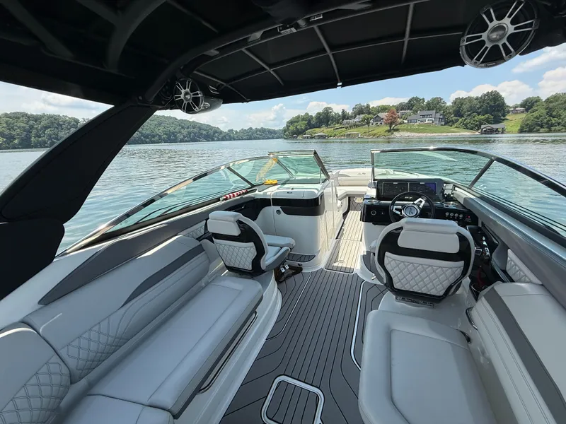 Slide: The Image of 2023 Sea Ray SLX 260 Surf boat interior with luxurious seating and modern dashboard on a serene lake. - 20