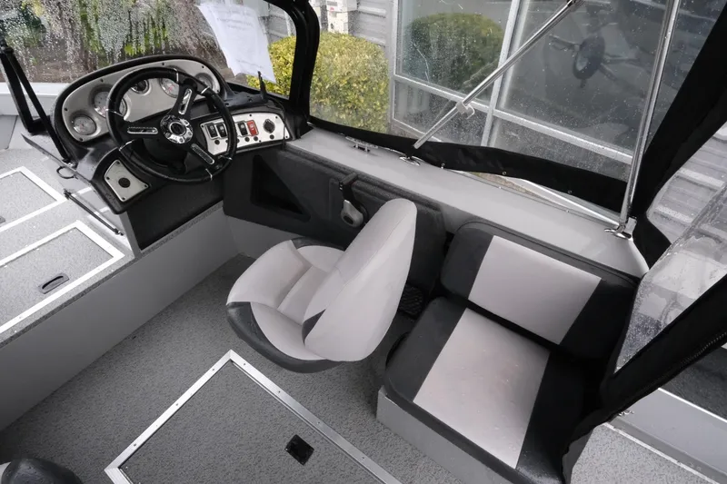 Slide: The Image of Interior view of 2023 SMOKERCRAFT 172 Osprey boat, featuring steering console and seating. - 12