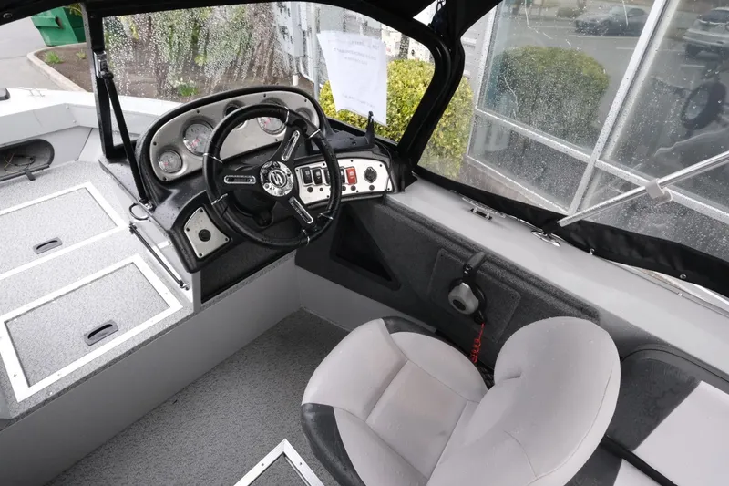 Slide: The Image of Interior of 2023 SMOKERCRAFT 172 Osprey boat showing steering wheel and dashboard controls. - 9