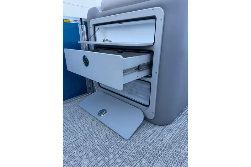 Slide: The Image of Open storage compartment on 2026 SunCatcher Select 22RF boat, featuring multiple drawers. - 16