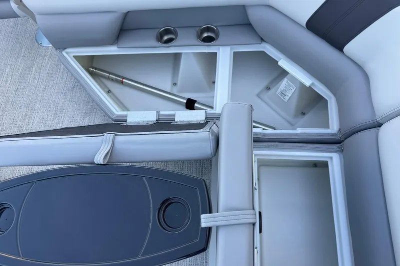 Slide: The Image of SunCatcher Select 22RF 2026 boat interior storage compartments with cup holders and seating. - 18