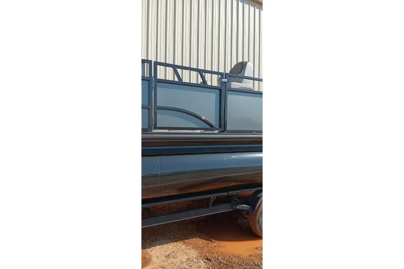 Slide: The Image of 2023 Ranger 2500LS pontoon boat parked near a metal building. - 18