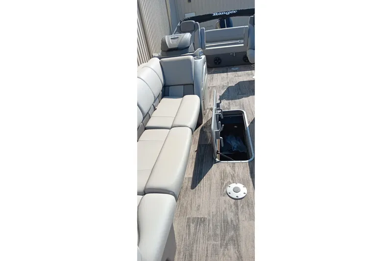 Slide: The Image of 2023 Ranger 2500LS boat interior with gray seating and open storage compartment. - 27