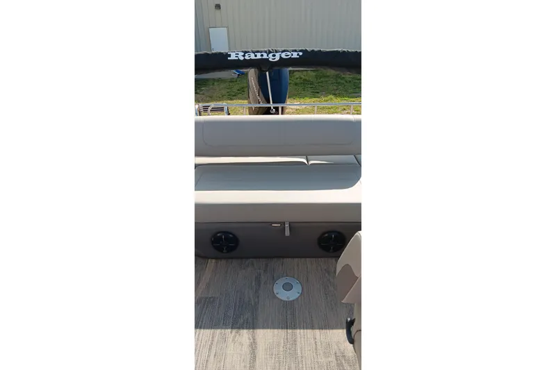 Slide: The Image of 2023 Ranger 2500LS boat interior with cushioned seating and wood-textured flooring. - 28