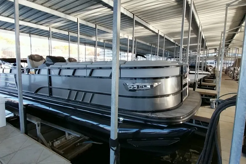 Slide: The Image of 2023 Ranger 2500LS pontoon boat docked in a covered marina. - 48