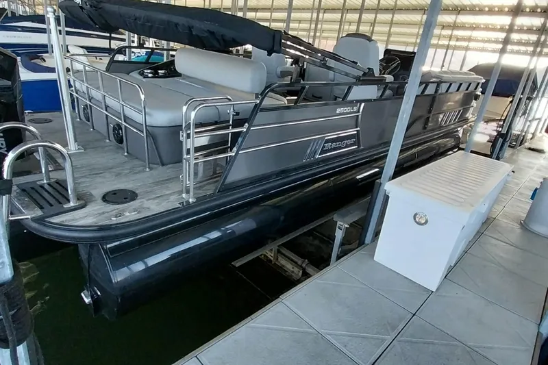 Slide: The Image of 2023 Ranger 2500LS pontoon boat docked in a covered marina. - 50