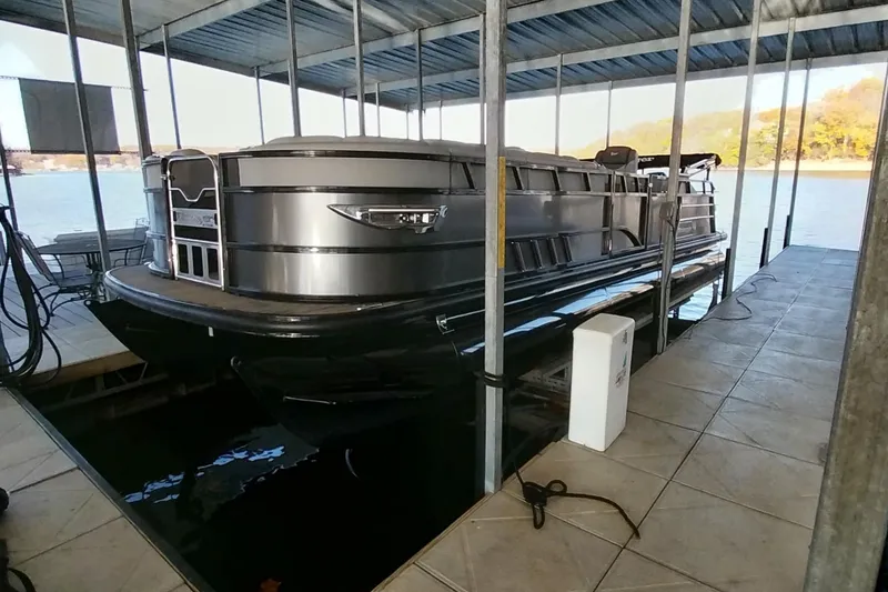 Slide: The Image of 2023 Ranger 2500LS pontoon boat docked under a covered marina. - 51