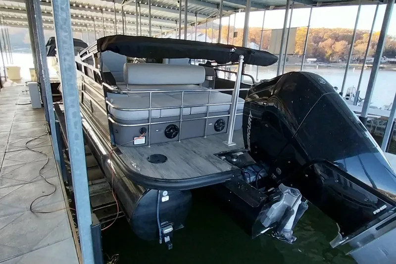Slide: The Image of 2023 Ranger 2500LS pontoon boat docked with powerful outboard motor. - 53