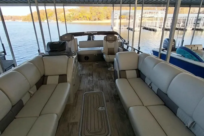 Slide: The Image of 2023 Ranger 2500LS pontoon boat interior with spacious seating and scenic lake view. - 58
