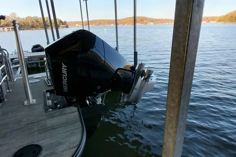 Slide: The Image of 2023 Ranger 2500LS boat with Mercury outboard motor docked on a serene lake. - 64
