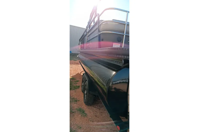 Slide: The Image of 2023 Ranger 2500LS boat with sleek black exterior, parked outdoors in sunlight. - 8