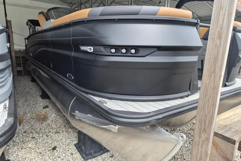 Slide: The Image of 2026 Sylvan L3 DLZ Bar pontoon boat with sleek black design in storage. - 16