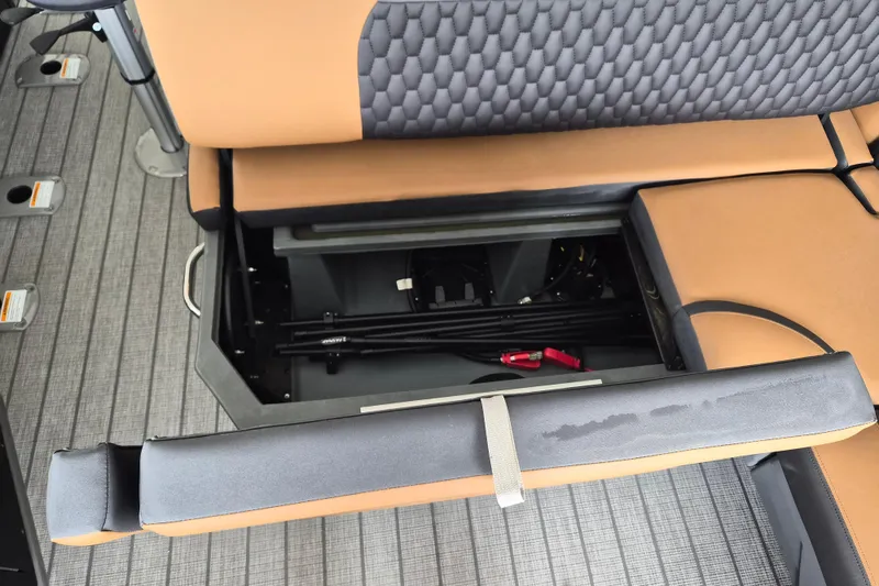 Slide: The Image of Under-seat storage compartment in 2026 Sylvan L3 DLZ Bar boat, featuring tan and gray upholstery. - 8