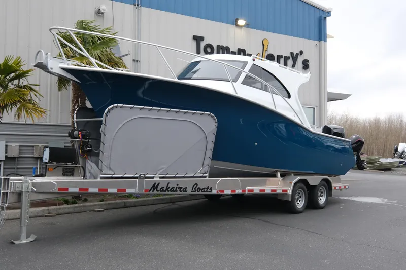 The Image of 2026 Makaira 28 boat on trailer outside Tom-n-Jerry's building. - 1