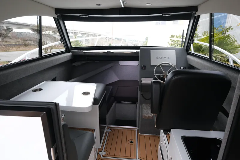 Slide: The Image of Interior of 2026 Makaira 28 boat with Garmin navigation system and seating area. - 12
