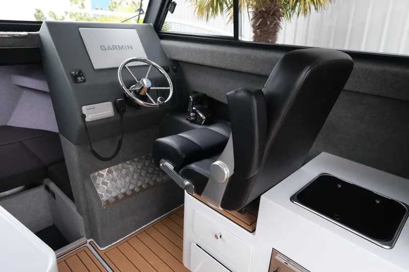 Slide: The Image of Interior of 2026 Makaira 28 boat with Garmin navigation system and black captain's chair. - 14