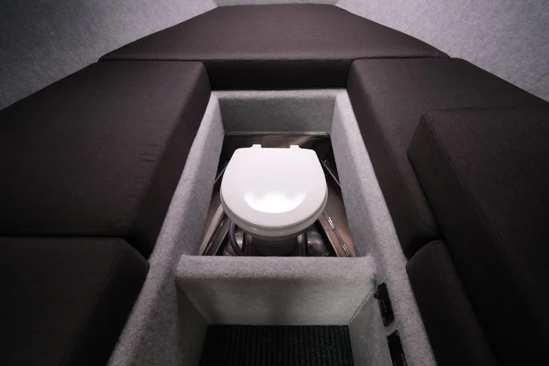 Slide: The Image of Interior of 2026 Makaira 28 boat featuring a compact marine toilet setup. - 19