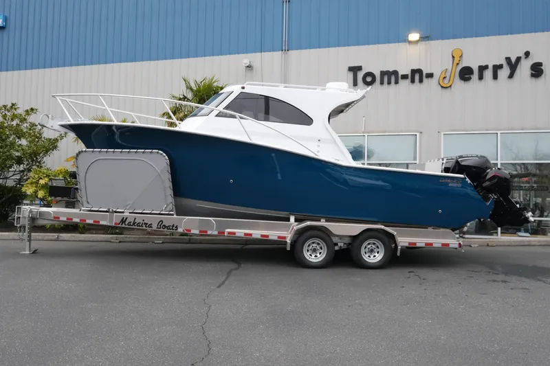 Slide: The Image of 2026 Makaira 28 boat on trailer outside Tom-n-Jerry's store. - 3