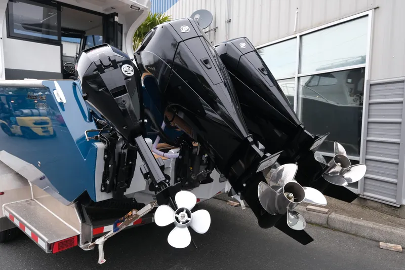 Slide: The Image of 2026 Makaira 28 boat with triple outboard engines, docked near a building. - 5