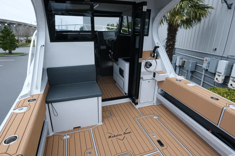 Slide: The Image of 2026 Makaira 28 boat interior with teak flooring and seating, showcasing modern design. - 7