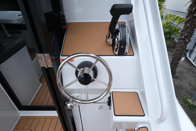 Slide: The Image of Steering wheel and controls of a 2026 Makaira 28 boat, featuring sleek design elements. - 8