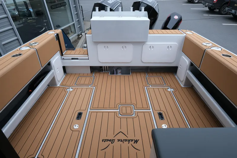Slide: The Image of Makaira 28 boat interior, 2026 model, featuring teak-style flooring and cushioned seating. - 9