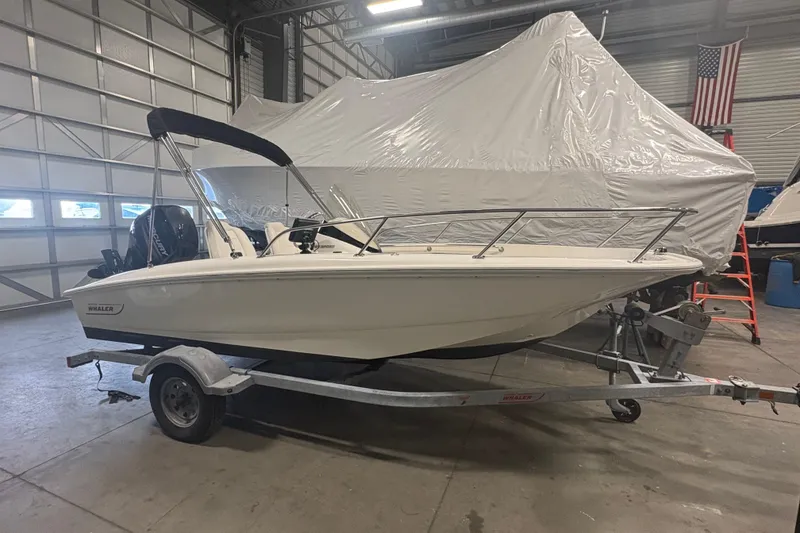 Slide: The Image of 2016 Boston Whaler 150 Super Sport boat on trailer in indoor storage facility. - 2