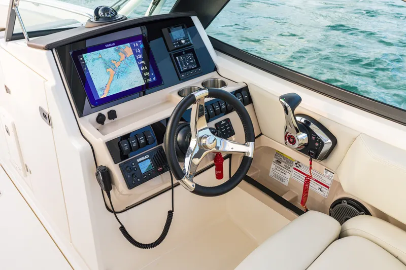 Slide: The Image of 2023 Boston Whaler 240 Vantage helm with navigation display and controls on water. - 2