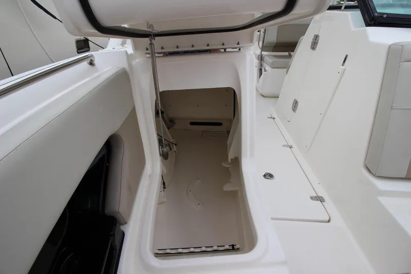 Slide: The Image of 2023 Boston Whaler 240 Vantage interior with storage cabinet and seating, overlooking water. - 25