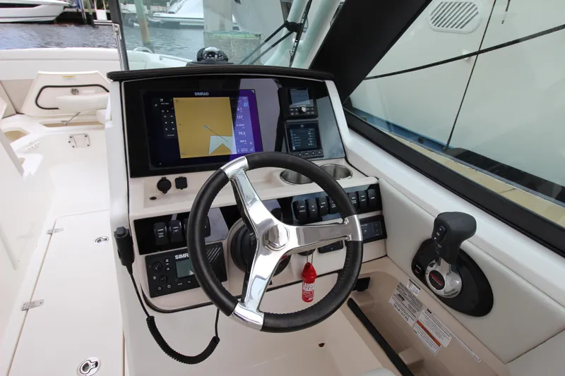 Slide: The Image of 2023 Boston Whaler 240 Vantage boat interior with open storage compartment, near water. - 28