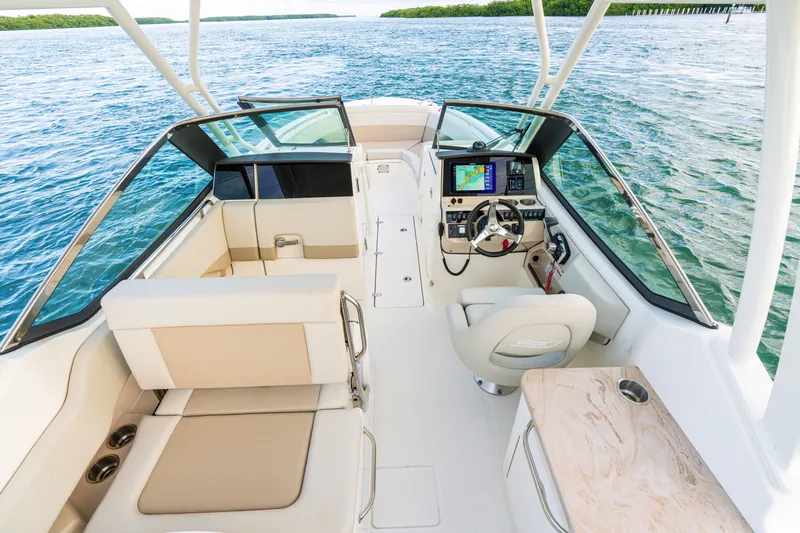 Slide: The Image of 2023 Boston Whaler 240 Vantage boat interior with helm, seating, and water view. - 4