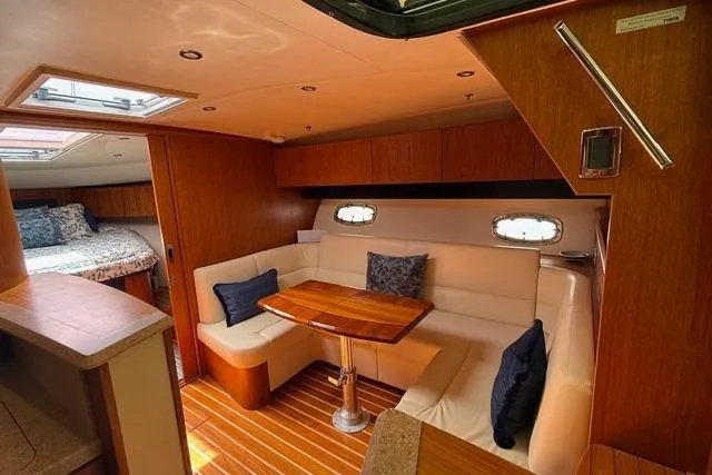Slide: The Image of Interior of 2010 Tiara Yachts 3900 Open, featuring cozy seating and elegant wood finishes. - 26
