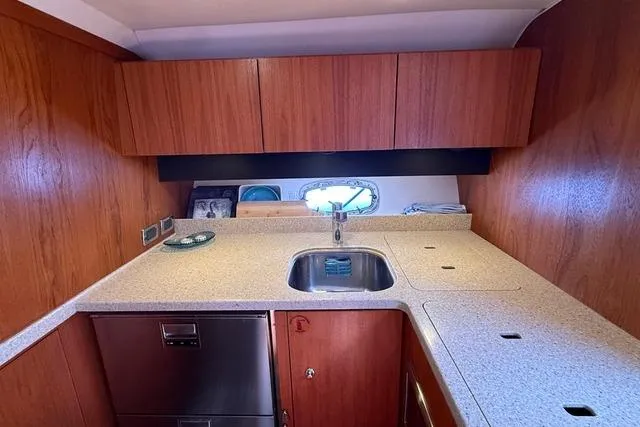 Slide: The Image of 2010 Tiara Yachts 3900 Open kitchen with wooden cabinets and modern sink. - 28