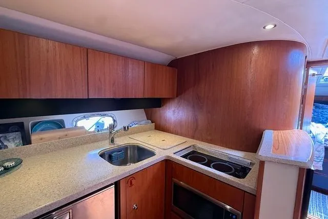 Slide: The Image of Luxurious 2010 Tiara Yachts 3900 Open kitchen with modern amenities and wood cabinetry. - 29
