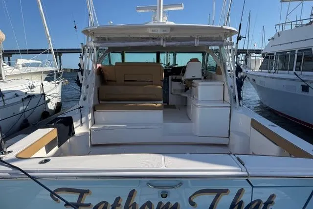 Slide: The Image of 2010 Tiara Yachts 3900 Open docked, showcasing spacious deck and seating area. - 3