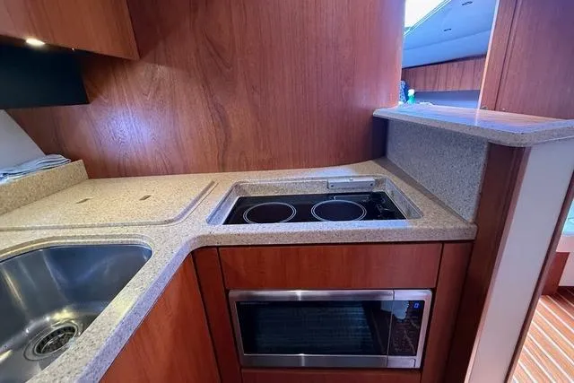 Slide: The Image of 2010 Tiara Yachts 3900 Open kitchen with stove, sink, and microwave. - 30