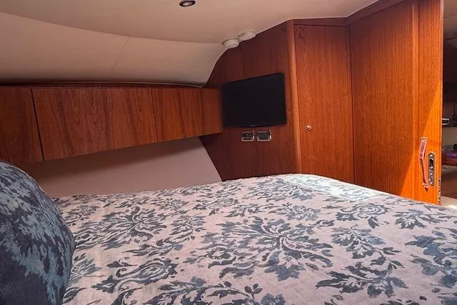 Slide: The Image of Interior cabin of 2010 Tiara Yachts 3900 Open with wood paneling and patterned bedding. - 35