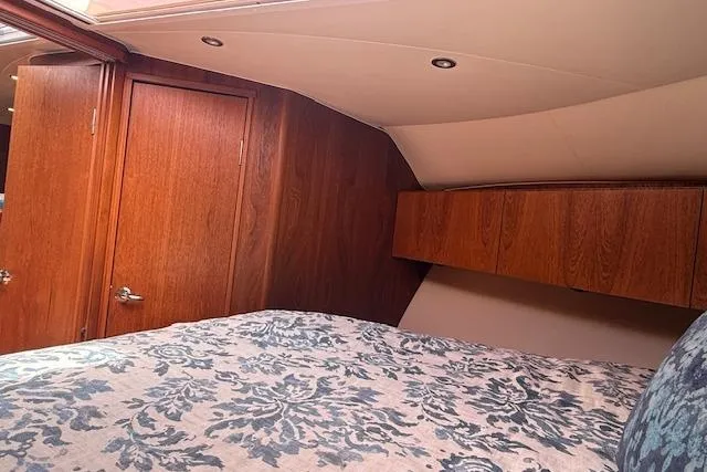 Slide: The Image of Interior cabin of 2010 Tiara Yachts 3900 Open, featuring wood paneling and patterned bedding. - 36