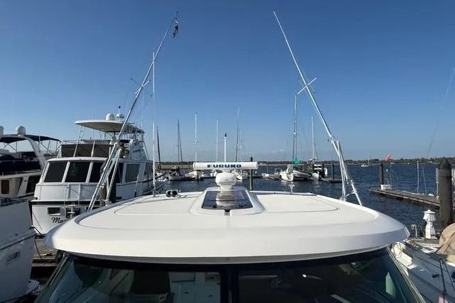 Slide: The Image of 2010 Tiara Yachts 3900 Open docked at a marina with clear blue skies. - 8