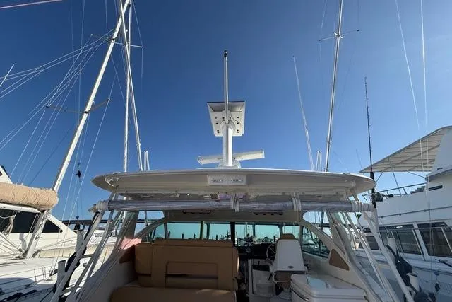 Slide: The Image of 2010 Tiara Yachts 3900 Open at marina, showcasing cockpit and seating under clear sky. - 9