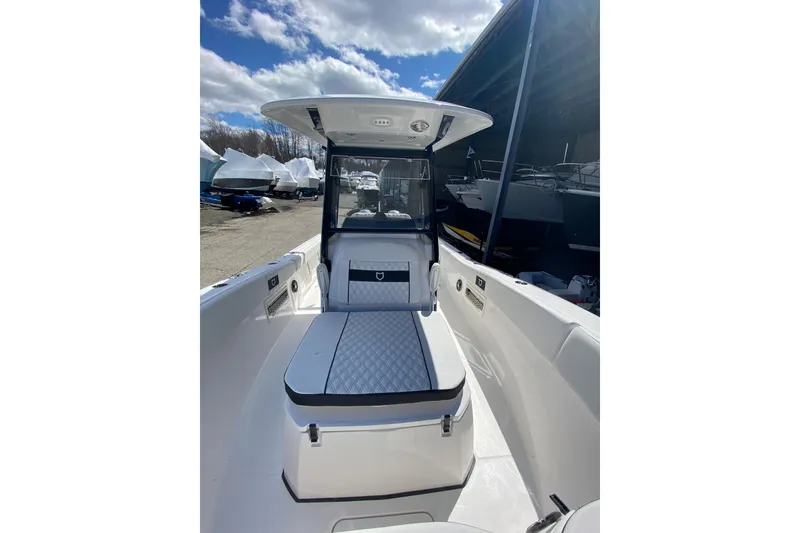 Slide: The Image of 2026 Sea Fox 268 Commander boat interior with cushioned seating under a clear blue sky. - 16