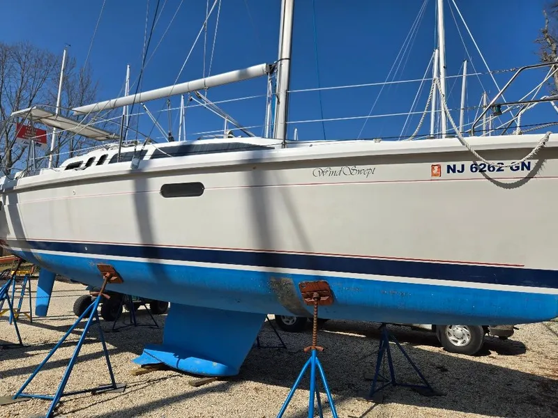 The Image of 1995 Hunter 336 sailboat on stands outdoors. - 0